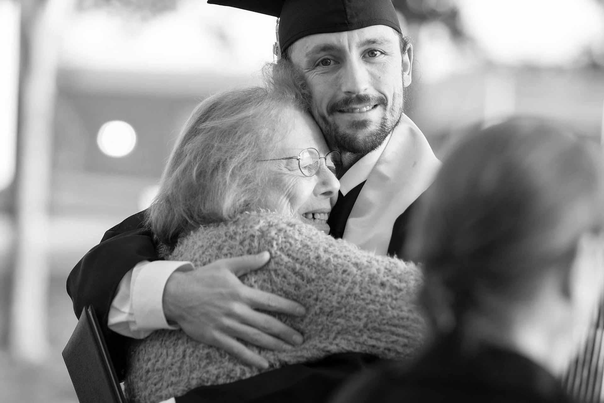 A happy male WPCC graduate hugs his mother at the end of the graduation ceremony
